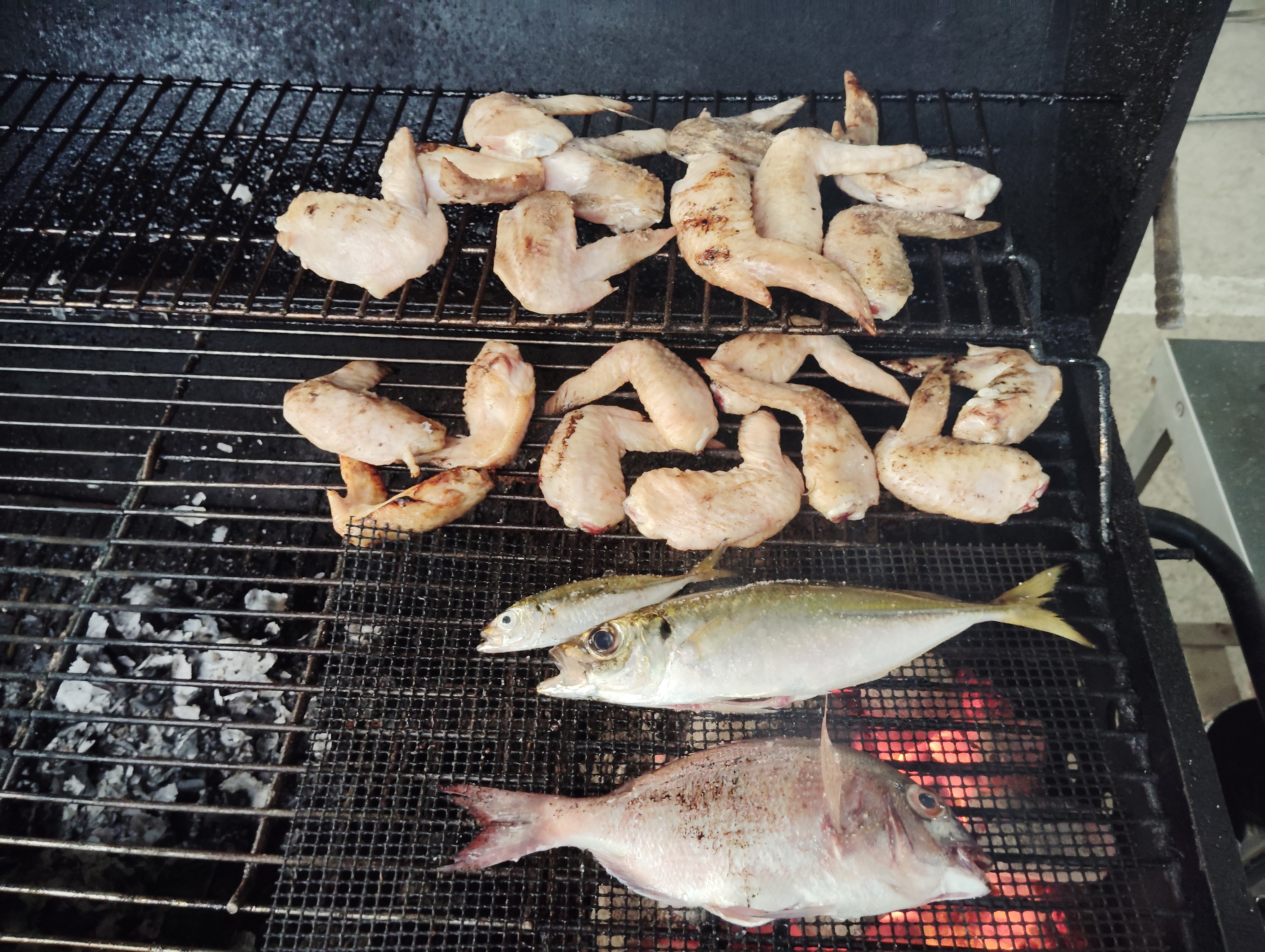 手羽先と魚をグリルに並べる